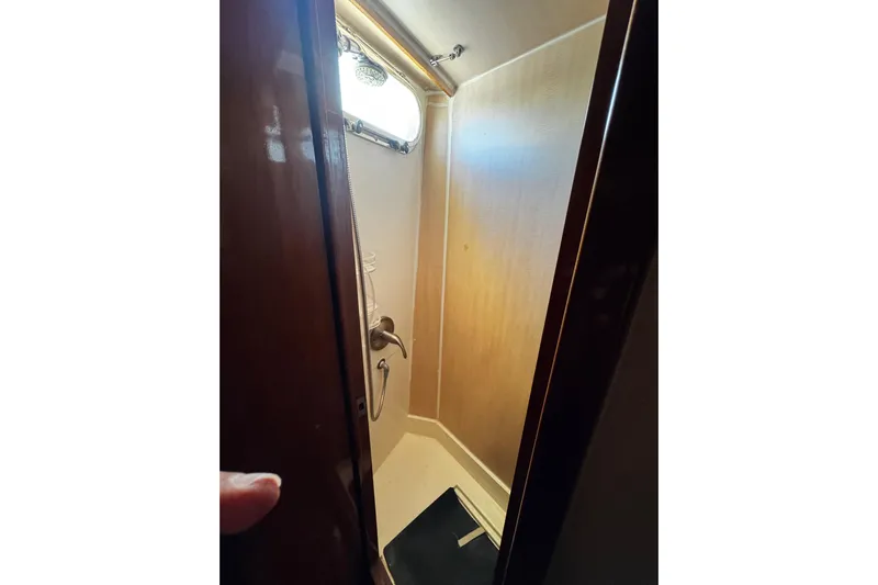Atlantis Yacht Photos Pics Shower area inside 1996 Hershine Benship 87 yacht, featuring wooden door and compact design.