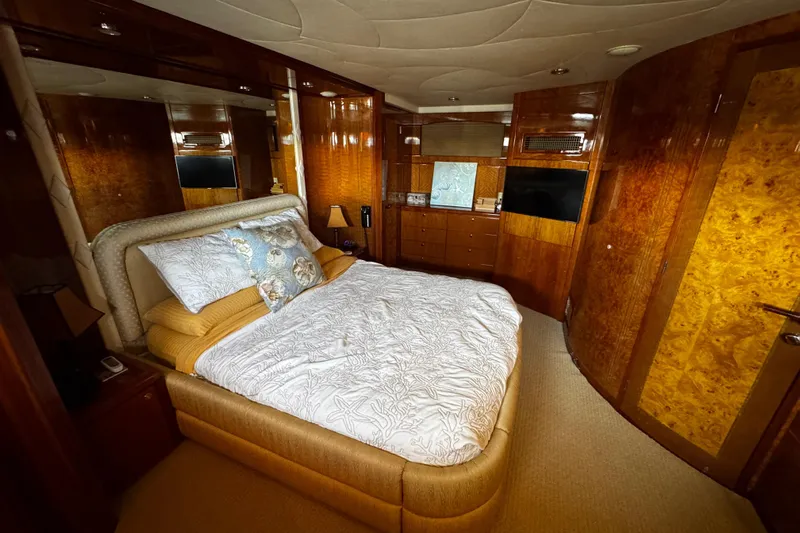 Atlantis Yacht Photos Pics Luxurious bedroom interior of 1996 Hershine Benship 87 yacht with elegant wood finishes.