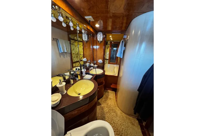 Atlantis Yacht Photos Pics Luxurious bathroom in 1996 Hershine Benship 87 yacht with dual sinks and elegant wood finish.