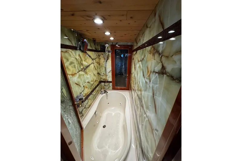 Atlantis Yacht Photos Pics Luxurious bathroom with marble walls and jacuzzi in 1996 Hershine Benship 87 yacht.