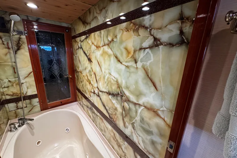 Atlantis Yacht Photos Pics Luxurious bathroom interior on 1996 Hershine Benship 87 yacht with marble walls and jacuzzi tub.
