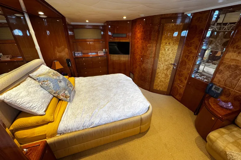 Atlantis Yacht Photos Pics Luxurious bedroom interior on 1996 Hershine Benship 87 yacht with elegant wood paneling.