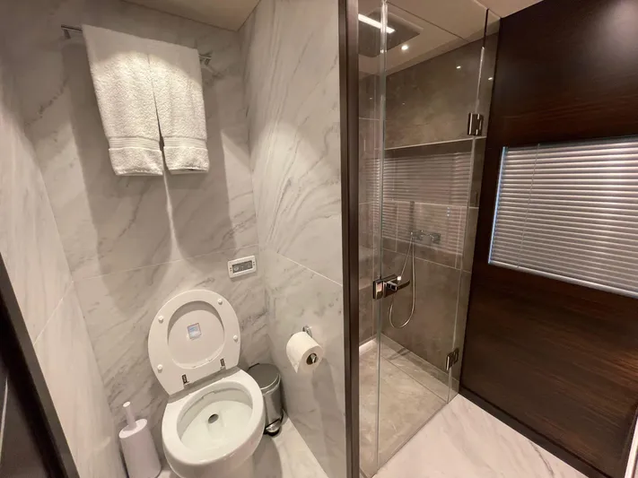  Yacht Photos Pics Luxurious bathroom in 2022 Sunseeker 88 Yacht with marble walls and glass shower.