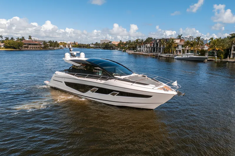 Lorena Yacht Photos Pics 2022 Sunseeker Predator 65 yacht cruising on a scenic waterway with luxury homes.