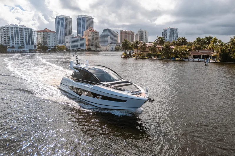 Lorena Yacht Photos Pics Luxurious 2022 Sunseeker Predator 65 yacht cruising near city skyline and waterfront homes.