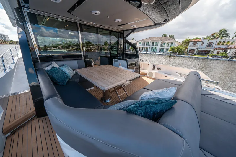 Lorena Yacht Photos Pics Luxurious 2022 Sunseeker Predator 65 yacht with elegant outdoor seating and scenic waterfront view.