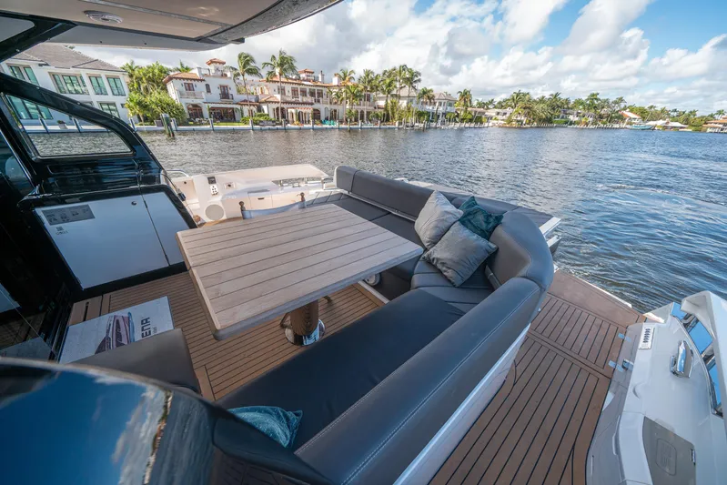 Lorena Yacht Photos Pics Luxurious Sunseeker Predator 65 yacht deck with seating, table, and waterfront view, 2022 model.