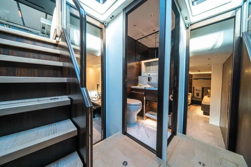 Lorena Yacht Photos Pics Luxurious interior of 2022 Sunseeker Predator 65 yacht, featuring modern bathroom and elegant staircase.