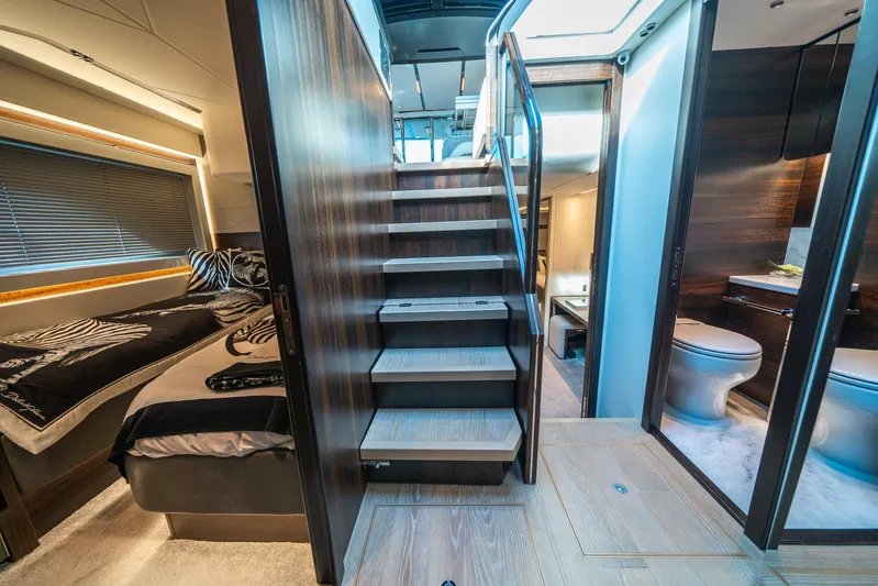 Lorena Yacht Photos Pics Luxurious interior of 2022 Sunseeker Predator 65 yacht featuring bedroom, staircase, and bathroom.