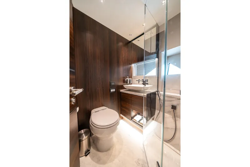 Lorena Yacht Photos Pics Luxurious bathroom in 2022 Sunseeker Predator 65 yacht with modern fixtures and wood accents.