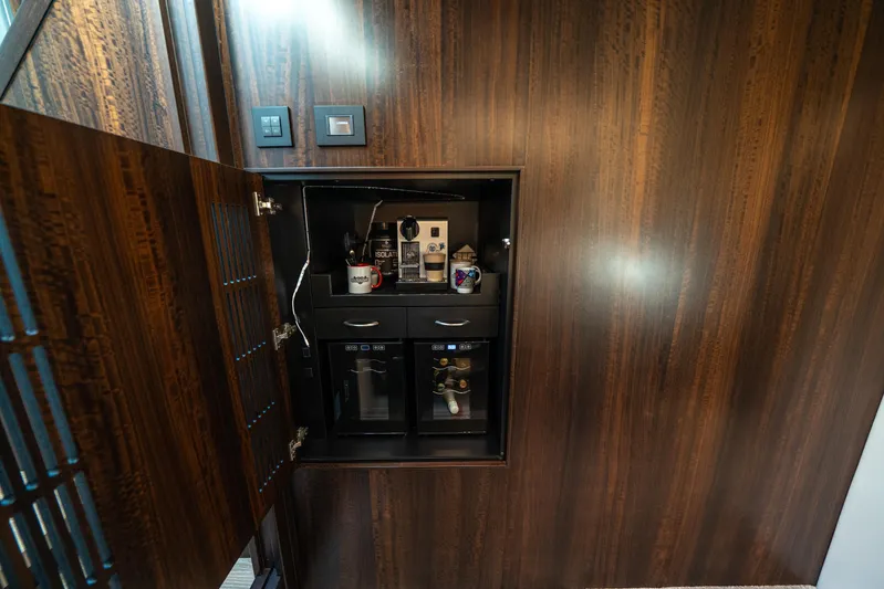 Lorena Yacht Photos Pics Luxury yacht Sunseeker Predator 65, 2022, features a sleek wooden cabinet with a built-in coffee station.