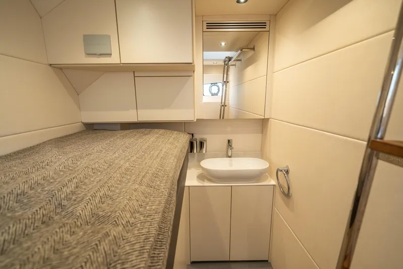 Lorena Yacht Photos Pics Luxurious interior of 2022 Sunseeker Predator 65 yacht with modern bathroom and cozy bed.