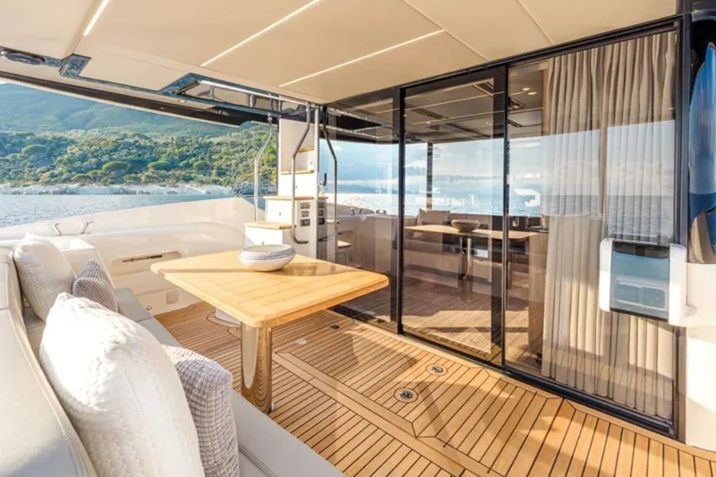  Yacht Photos Pics Luxurious 2024 Absolute NAVETTA 52 yacht interior with elegant wood finish and scenic ocean view.