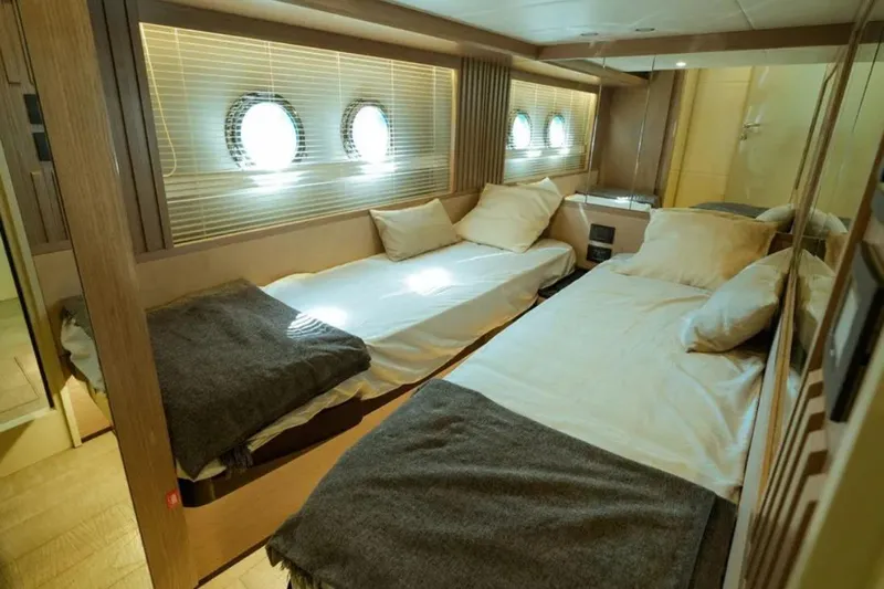  Yacht Photos Pics Luxurious twin cabin interior of 2024 Absolute NAVETTA 52 yacht with porthole windows.