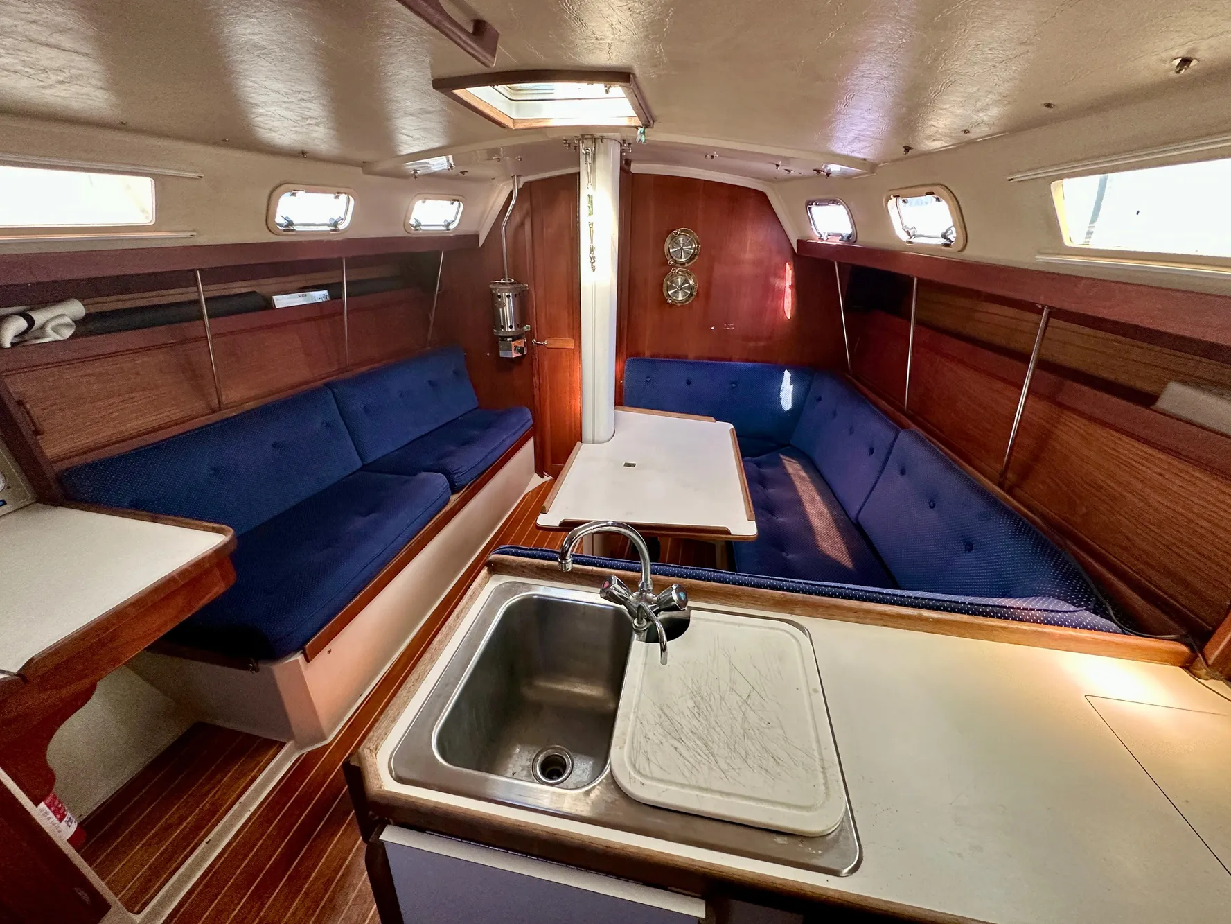 Interior of a 1987 Catalina 34 yacht with blue upholstery.