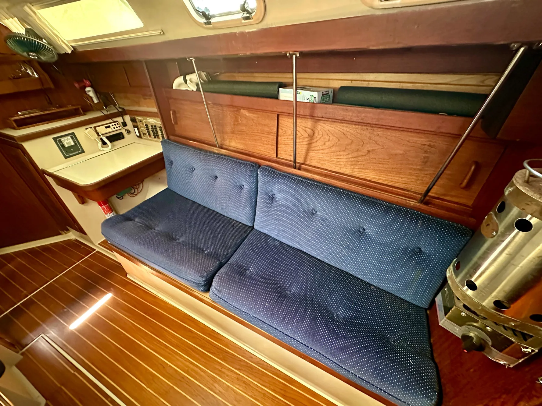 Interior of a 1987 Catalina 34 yacht with blue couch and wood finish.