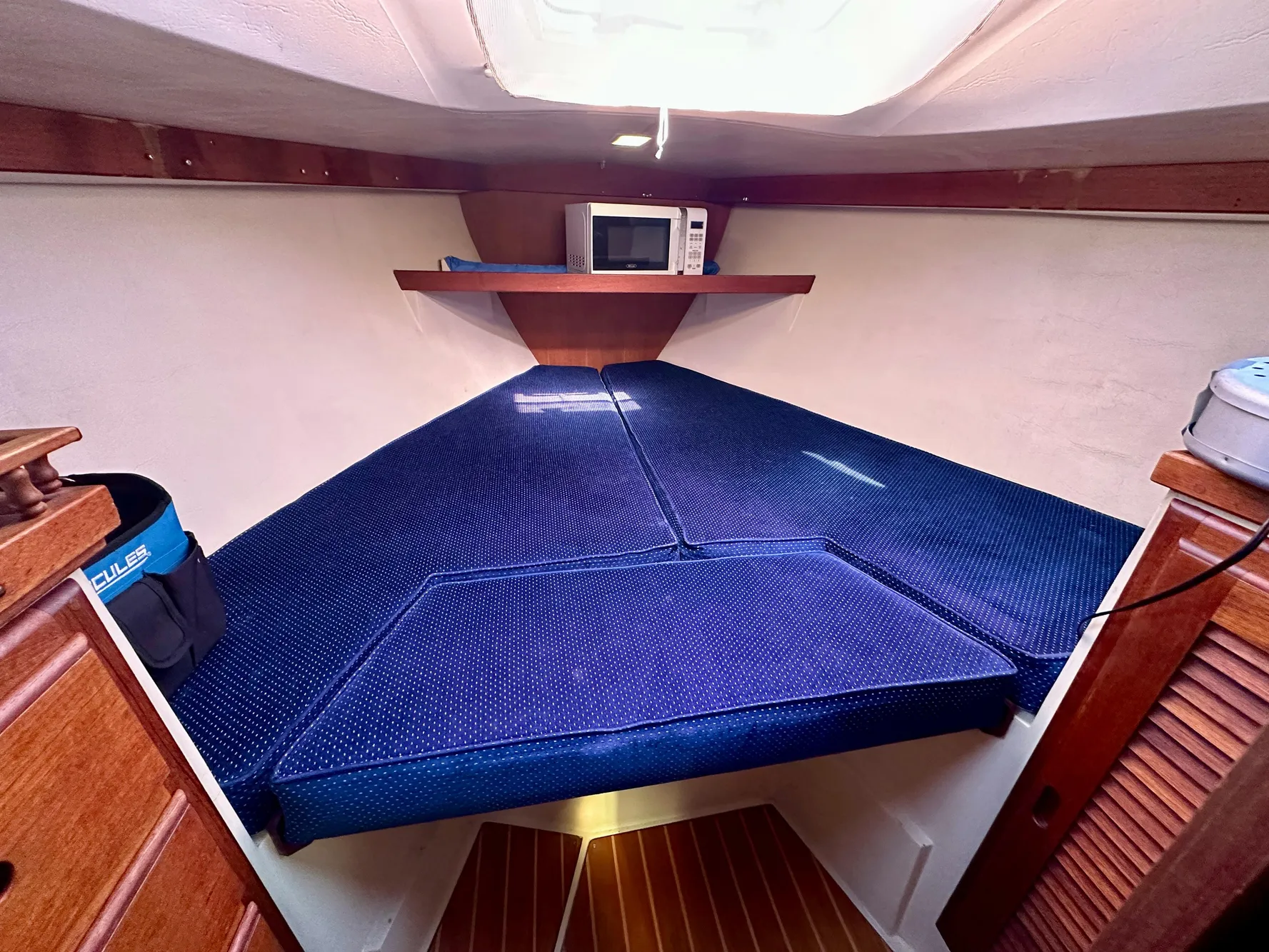 Interior of a 1987 Catalina 34 with blue upholstery and microwave.
