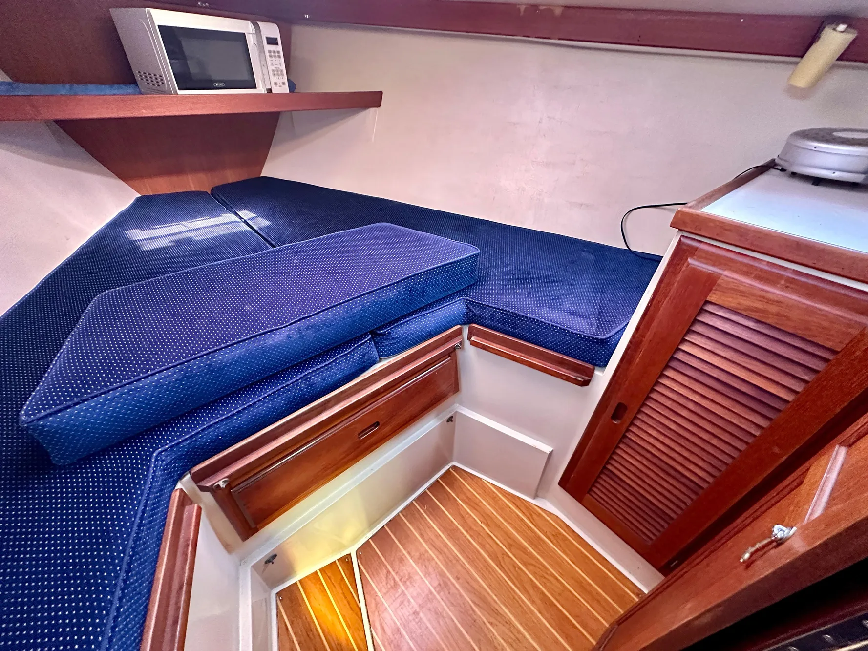 Interior of a 1987 Catalina 34 yacht with blue cushions.
