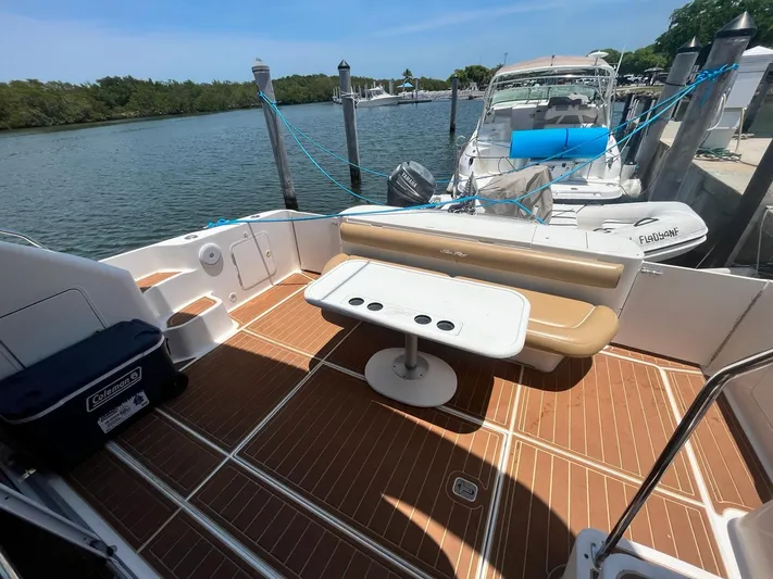 Pal'party Yacht Photos Pics 2000 Sea Ray 450 Express Bridge boat deck with seating and table, docked at marina.