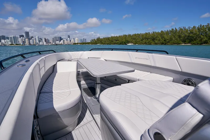  Yacht Photos Pics 2020 Midnight Express 37' Open boat with luxurious seating and table, city skyline in background.