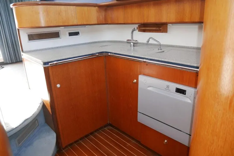  Yacht Photos Pics Kitchen area of 1994 Fairline Phantom 37 yacht with wooden cabinetry and modern appliances.