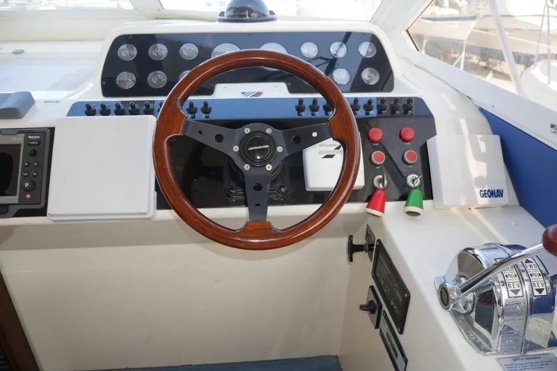  Yacht Photos Pics Cockpit of 1994 Fairline Phantom 37 yacht with wooden steering wheel and control panel.