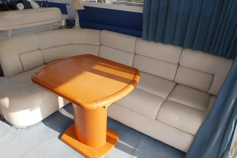  Yacht Photos Pics Interior of 1994 Fairline Phantom 37 yacht with beige seating and wooden table.