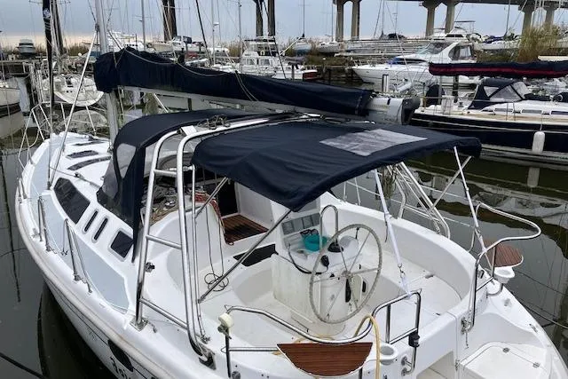 Sailboat Hunter 380, 2000 model, docked in a marina with covered cockpit.