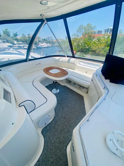 Blue Pearl Yacht Photos Pics 2006 Sea Ray 580 Sedan Bridge interior with seating and table, overlooking marina.
