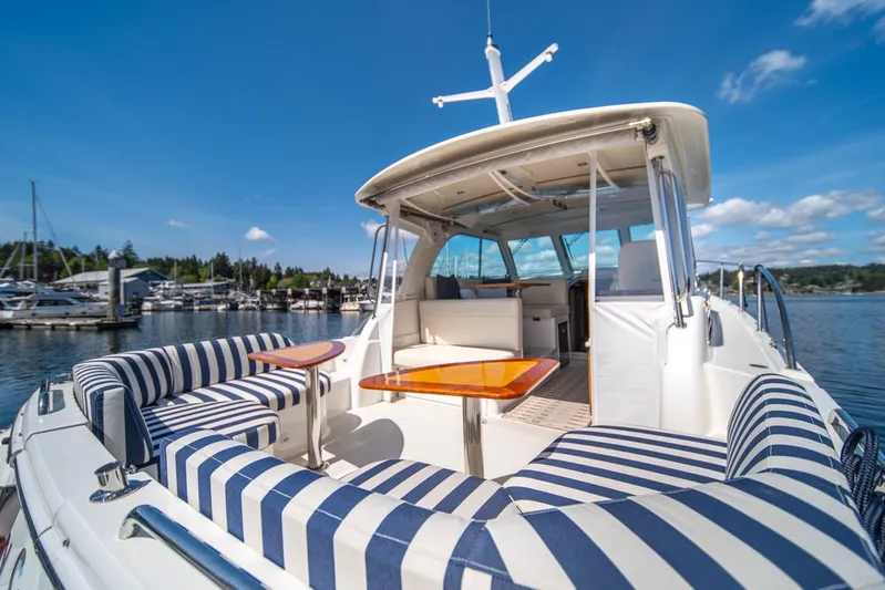 Eastern Standard Yacht Photos Pics 2021 Back Cove 34O yacht with striped seating, docked under a clear blue sky.