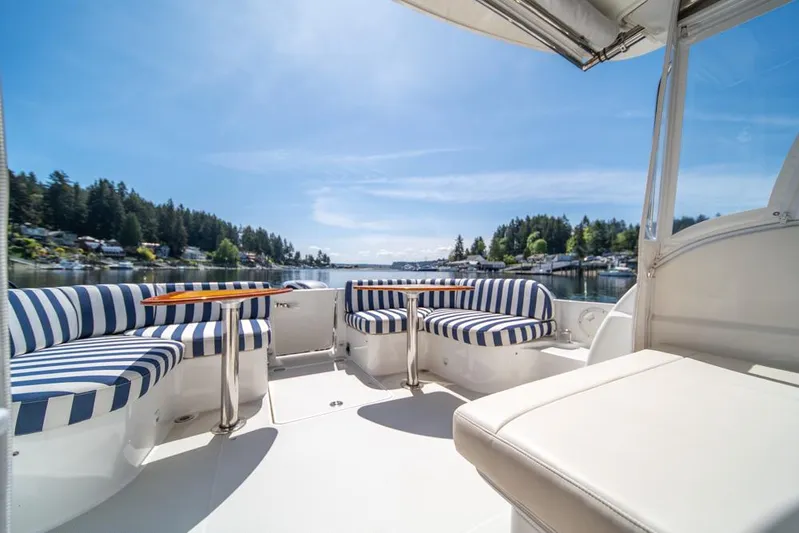 Eastern Standard Yacht Photos Pics 2021 Back Cove 34O boat with striped seating, scenic lake view.