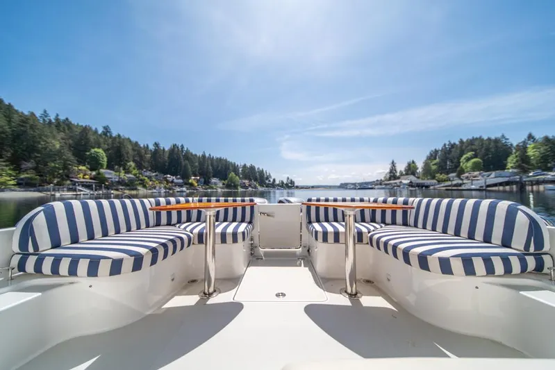 Eastern Standard Yacht Photos Pics 2021 Back Cove 34O boat with striped seating, scenic water view, and clear blue sky.