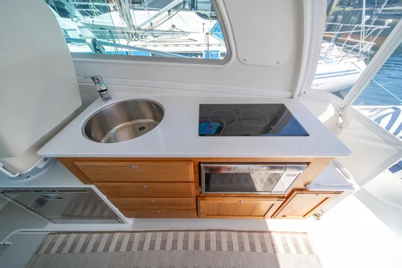 Eastern Standard Yacht Photos Pics 2021 Back Cove 34O yacht kitchen with sink, stove, and wooden cabinetry.