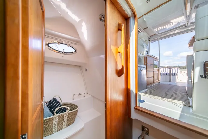 Eastern Standard Yacht Photos Pics Interior view of 2021 Back Cove 34O yacht, featuring wooden cabinetry and a cozy seating area.