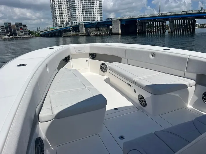  Yacht Photos Pics 2024 SeaVee 390Z boat interior with spacious seating, docked near a bridge and cityscape.