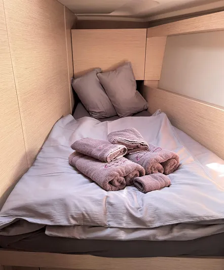  Yacht Photos Pics Cozy cabin interior of 2020 Hanse 458 yacht with neatly arranged towels on bed.