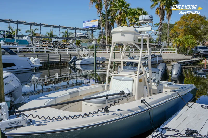  Yacht Photos Pics Young 27 boat docked at marina, surrounded by palm trees and clear blue sky.