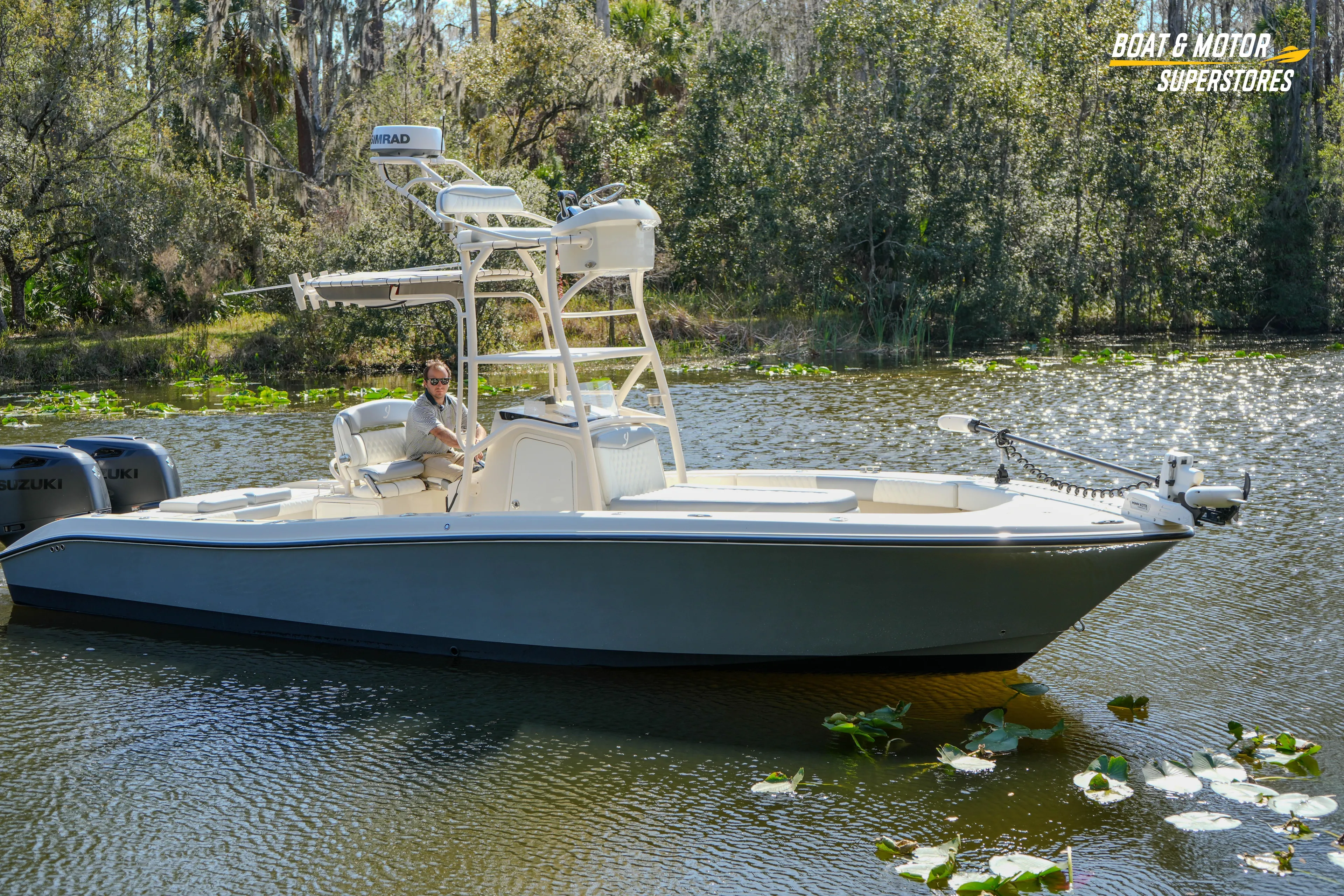  Yacht Photos Pics Young 27 boat from 2016 on a serene lake, surrounded by lush greenery.