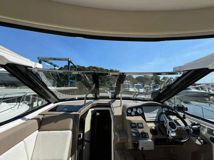 Ripple Yacht Photos Pics Interior view of 2016 Regal 35 Sport Coupe cockpit with steering wheel and dashboard.