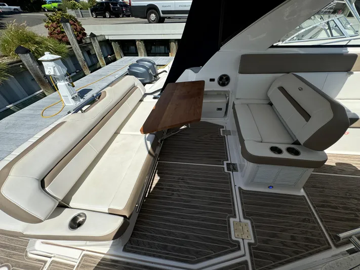 Ripple Yacht Photos Pics 2016 Regal 35 Sport Coupe interior with seating and wooden table.