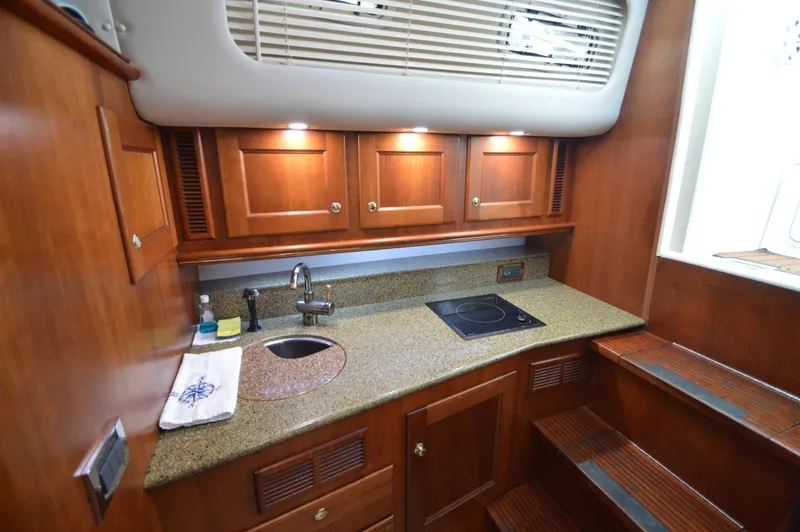 Side Chick Yacht Photos Pics Luxurious 2002 Rampage 38 Express yacht kitchen with wood cabinetry and modern amenities.
