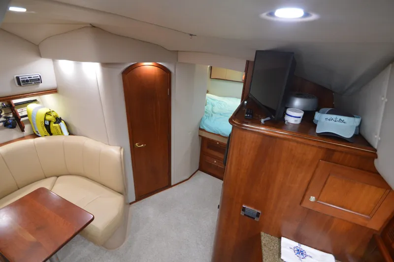 Side Chick Yacht Photos Pics 2002 Rampage 38 Express cabin interior with seating, table, and wooden cabinetry.