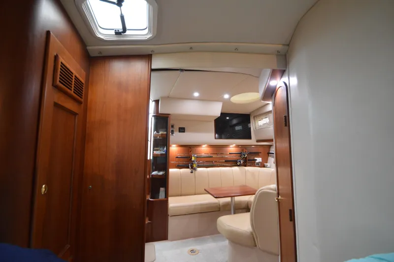 Side Chick Yacht Photos Pics Interior of 2002 Rampage 38 Express yacht with wood paneling and seating area.