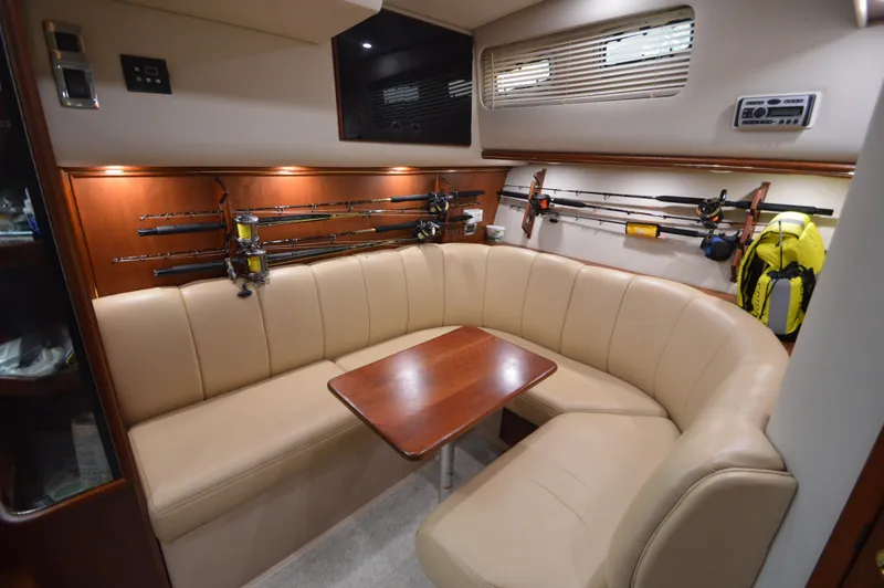 Side Chick Yacht Photos Pics Luxurious interior of 2002 Rampage 38 Express yacht with fishing rods and beige seating.