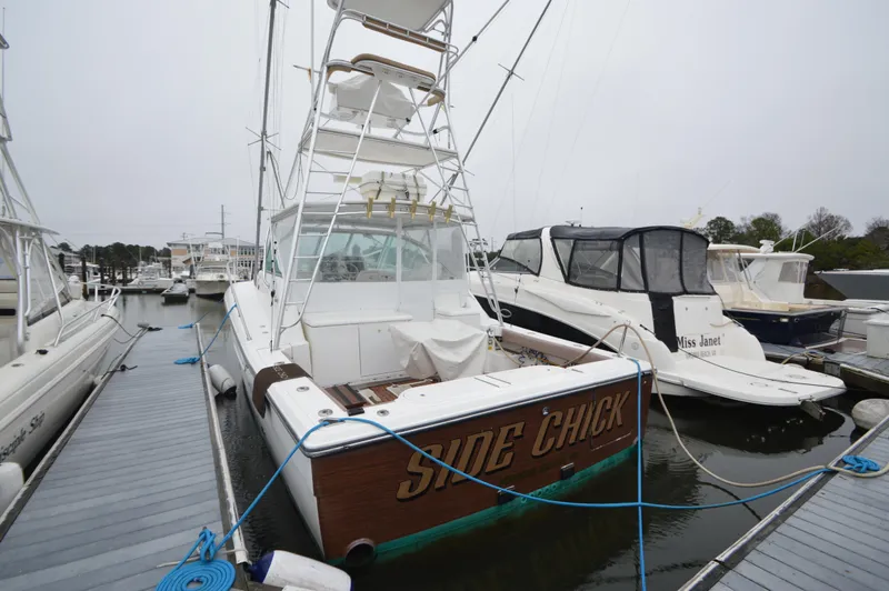 Side Chick Yacht Photos Pics 2002 Rampage 38 Express boat docked at marina, rear view.