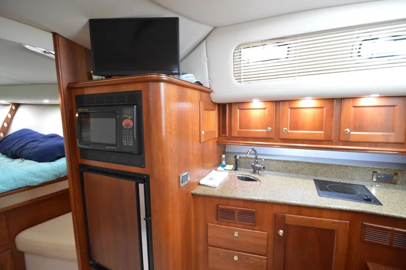 Side Chick Yacht Photos Pics Luxurious 2002 Rampage 38 Express yacht interior with kitchenette and sleeping area.