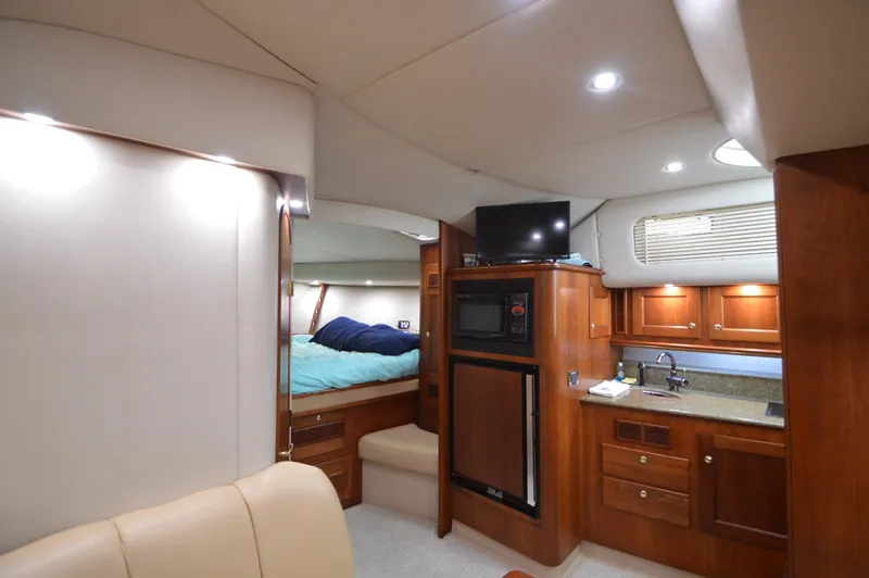 Side Chick Yacht Photos Pics Interior of 2002 Rampage 38 Express yacht with cozy cabin and kitchenette.