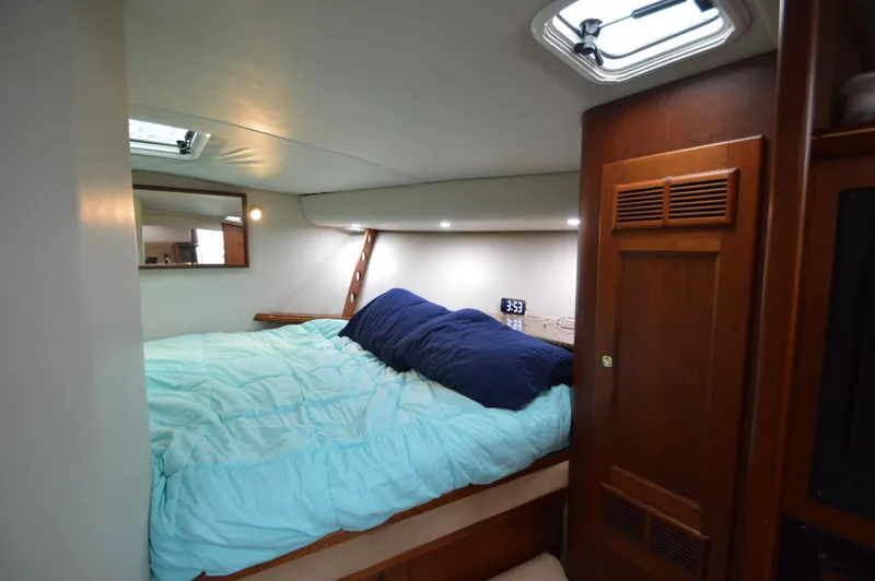 Side Chick Yacht Photos Pics Cozy cabin interior of 2002 Rampage 38 Express with bed and wooden accents.