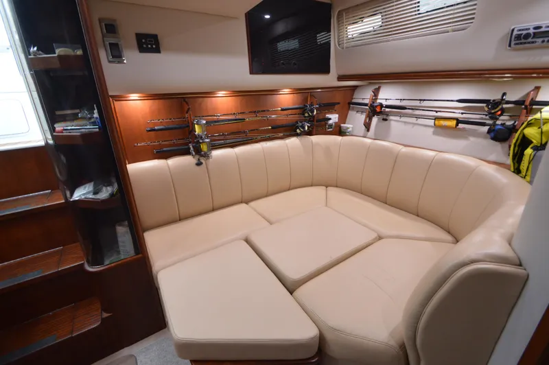 Side Chick Yacht Photos Pics Luxurious interior of 2002 Rampage 38 Express yacht with beige seating and fishing rods.