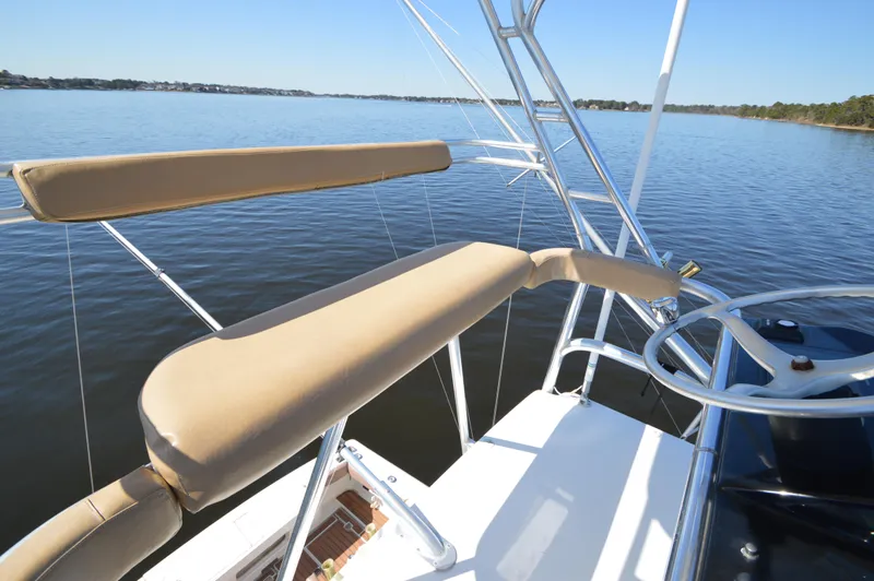 Side Chick Yacht Photos Pics 2002 Rampage 38 Express boat helm with cushioned seating on calm water.